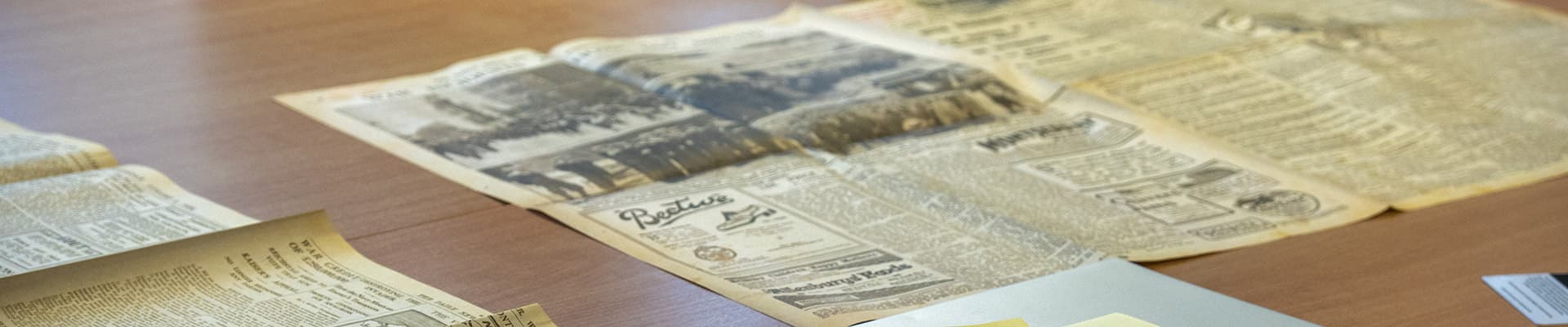 Various old newspaper cuttings displayed on a table