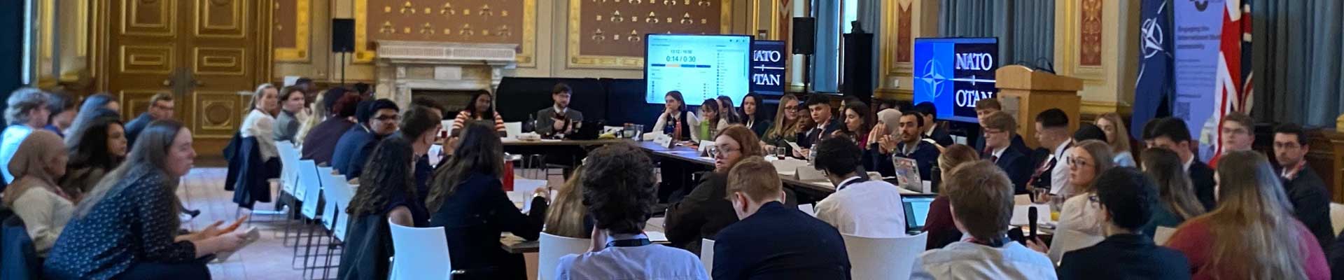 a large group of students sat round a conference table