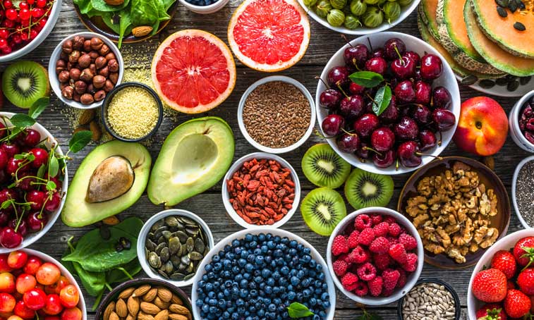 table full of colourful fruits, nuts and berries 