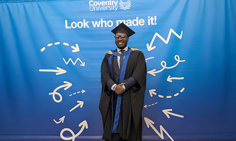 Freeman Faithful stood smiling in his graduation gown and cap