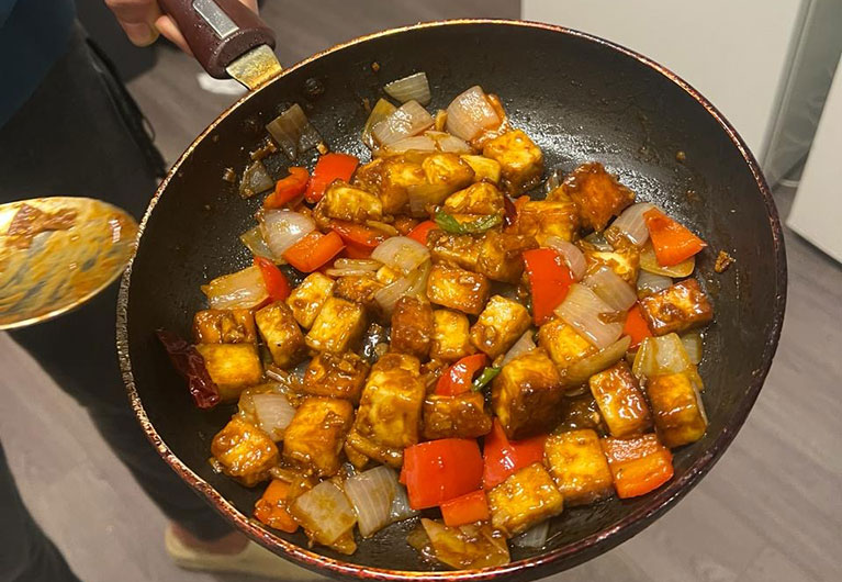 Person holding food in a pan