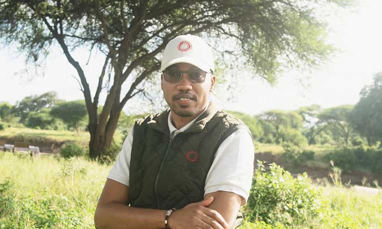 Alan Peters at Nomad Safari in Tanzania. Alan is standing in a safari field