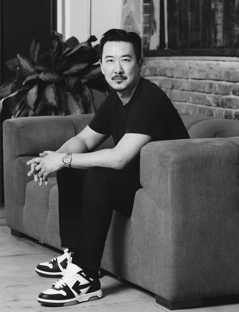 David Imai sat on a sofa in a modern office setting