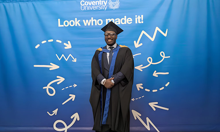 Freeman Faithful stood smiling in his graduation gown and cap
