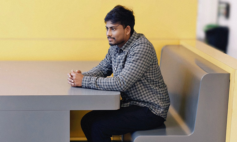 Gopi Parasuraman sitting in a booth in the student hub