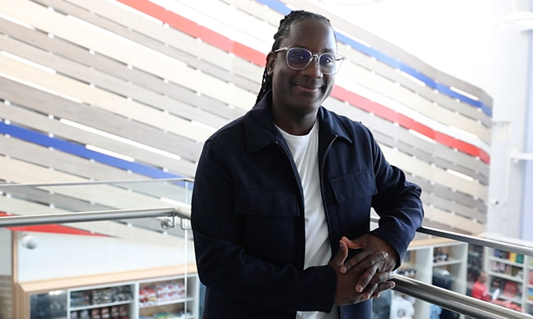 James Dornor leaning on a banister and smiling at the camera