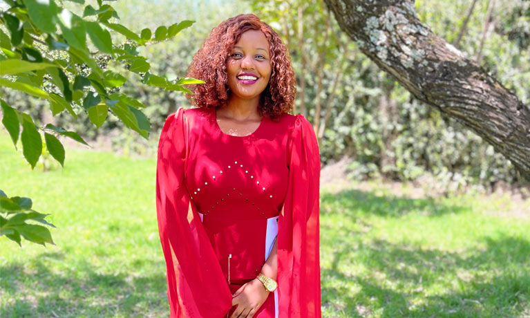 Mercy Tomboy smiling next to a tree