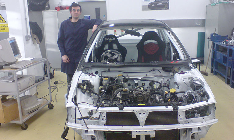 Raoul leaning against a car he has been working on