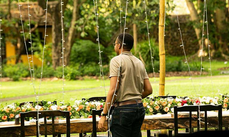 Alan standing at an outside banquet table at Plant Lodges Tanzania