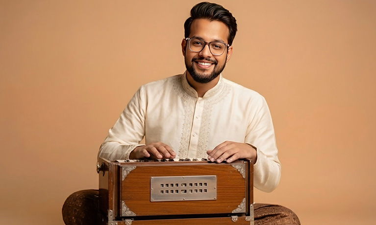 Sadakat Khan portrait smiling with his Bhava Studio Harmonium