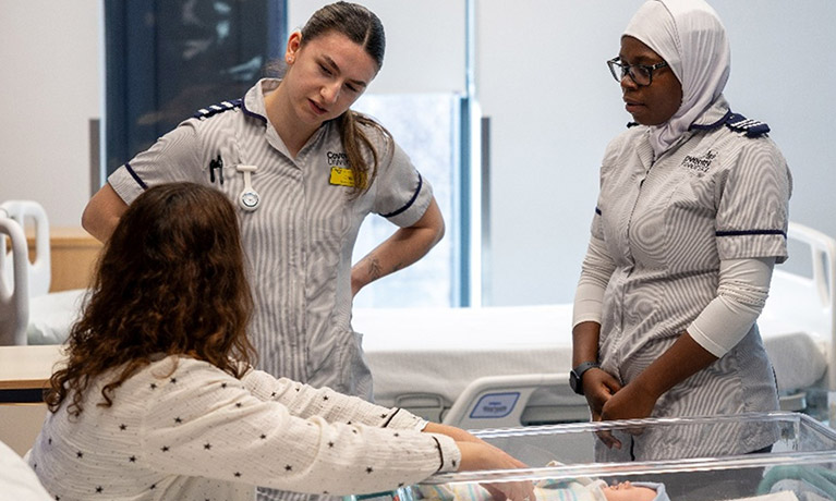 student nurses talking in  a mock hospital ward