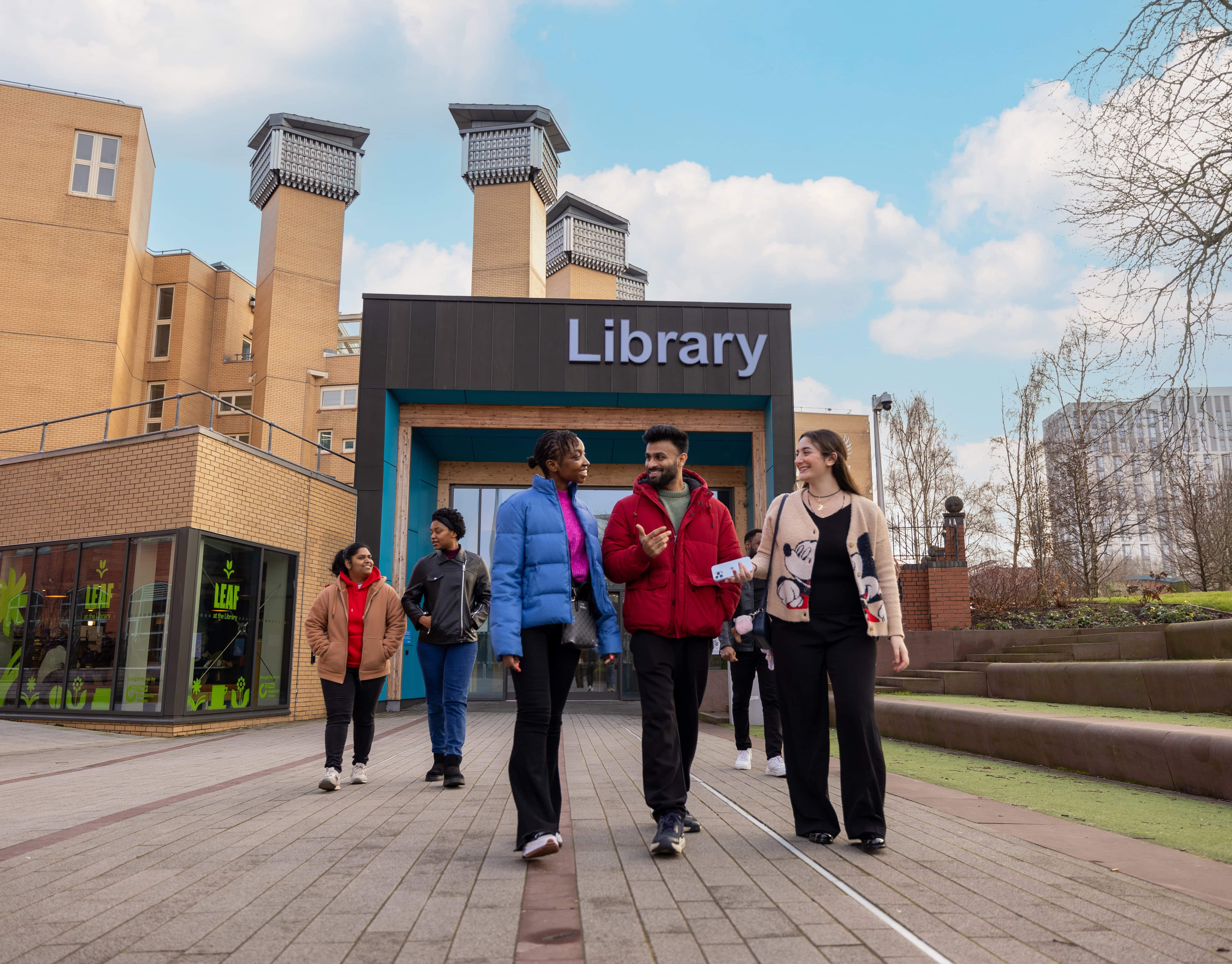 Students walking toether outside of the library building