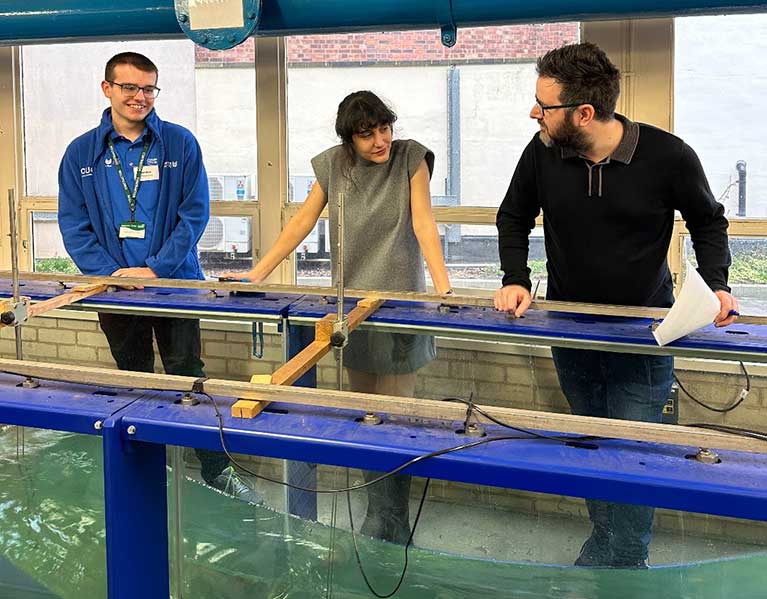 Matthew Hoult stood next to two lecturers looking into a tank