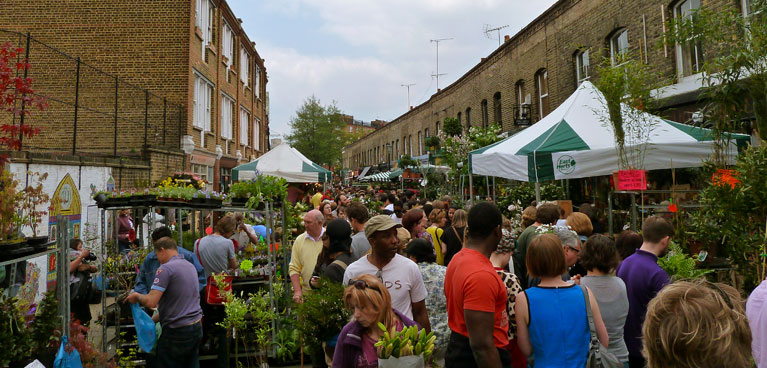 A view of Columbia Road with flower market stalls set up and crowds