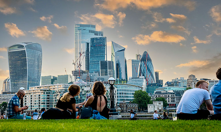 People sitting in a park overlooking London city
