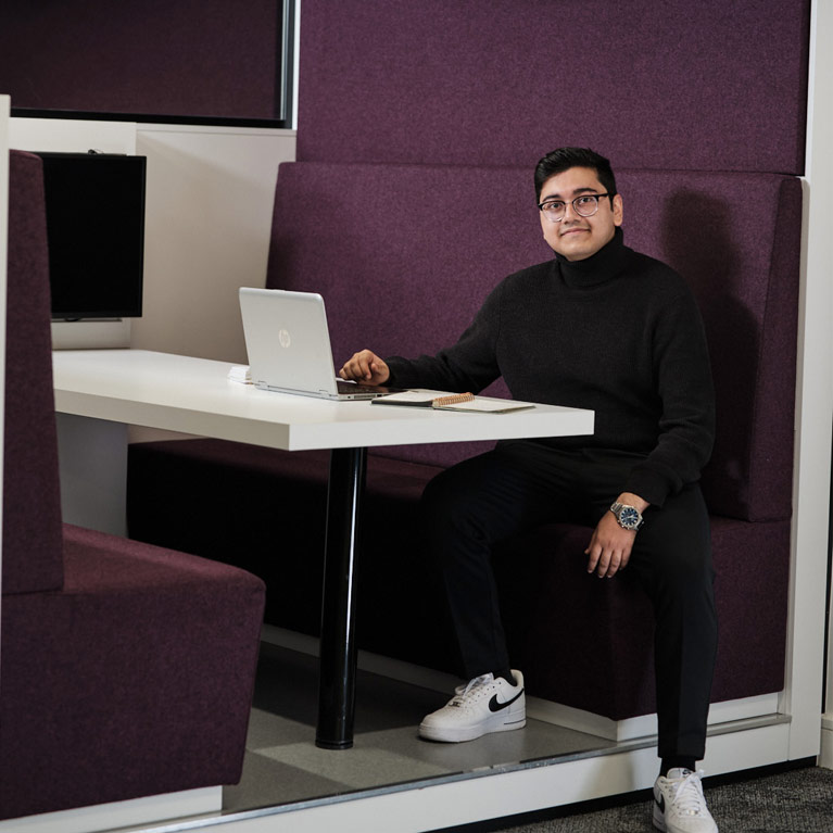 Shaikh in a study space on campus