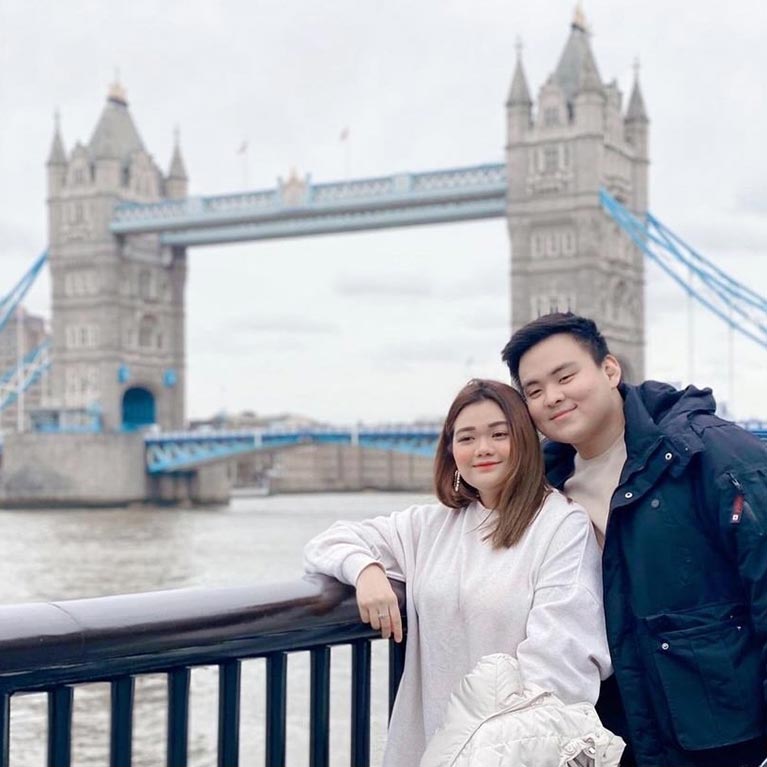 couple posing in front of tower bridge