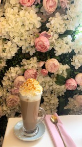 Glass of hot chocolate in front of some flowers