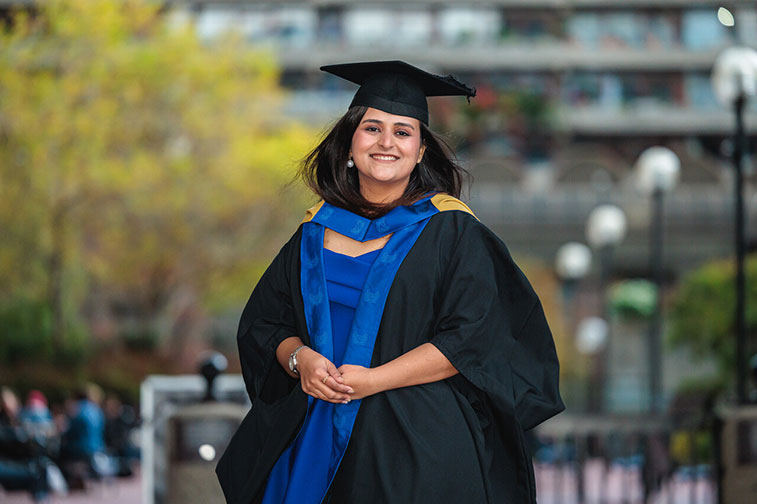 Nancy Batra smiling in her graduation gown and cap