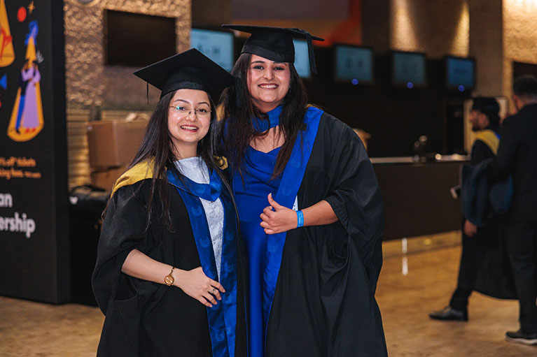 Nancy Batra smiling with another graduate during graduation