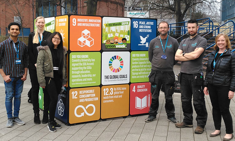 A group of students stood by a cube with different logos on it