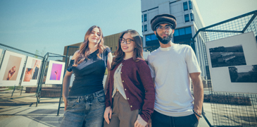 three students smiling outside