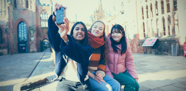 three students taking a selfie at Coventry cathedral