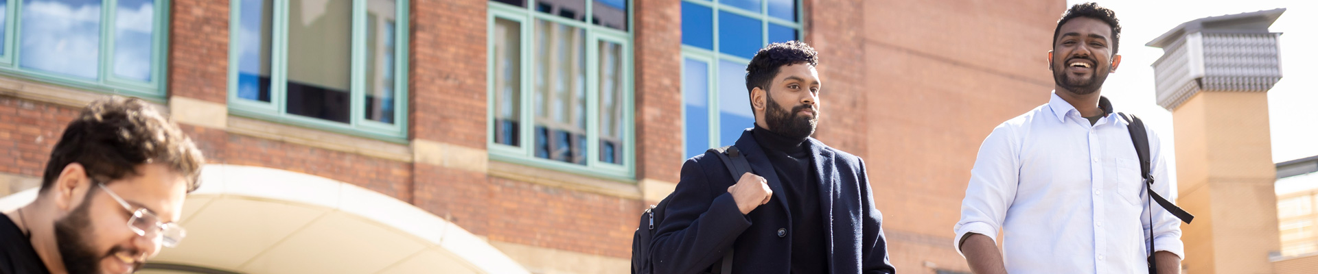Two international students walking outside on campus.