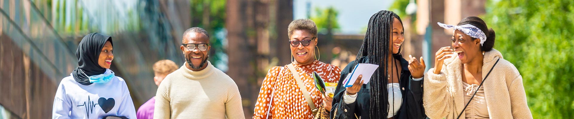 A family smiling on campus at a Coventry University Open Day.
