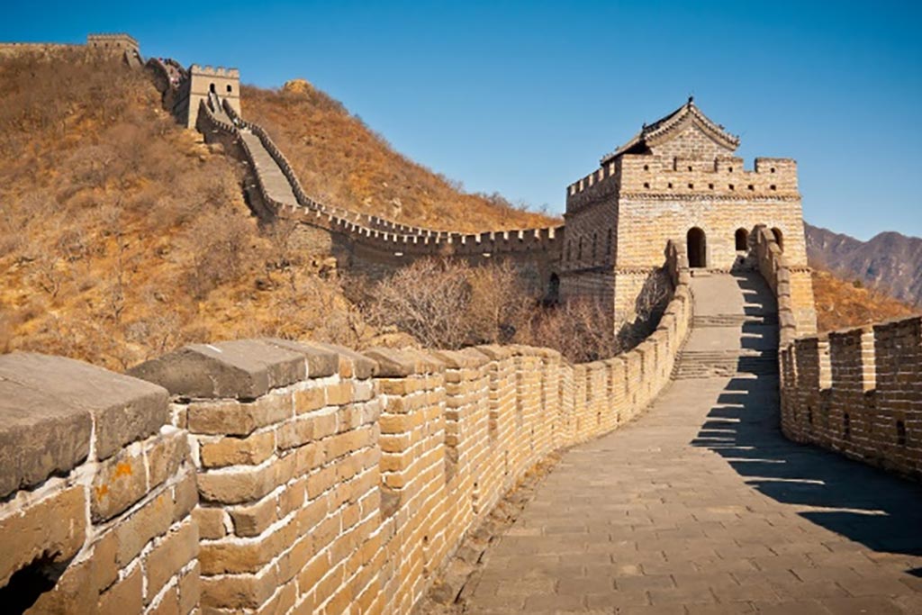 A view of the great wall of China leading up across a hill.