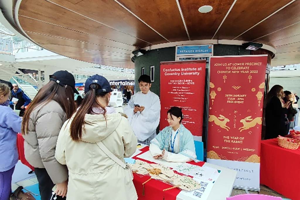 People surround a Confucius Institute information stand in Coventry city centre.