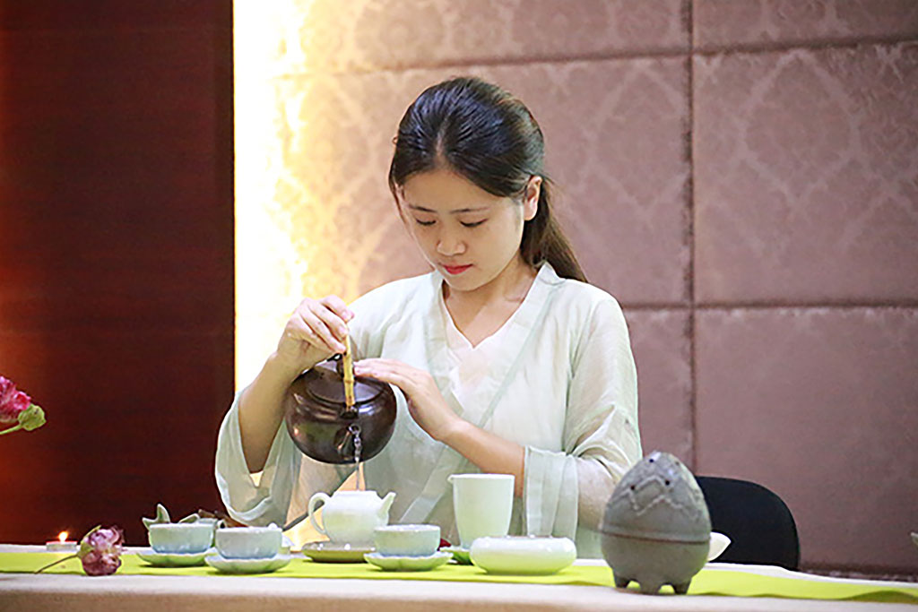 A woman pouring out tea in a Chinese tea ceremony.