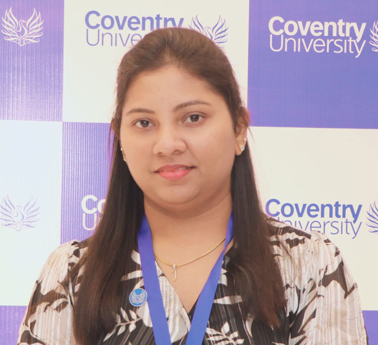 Portrait of Joan Felina Fernandez against a Coventry University banner in the background. Portrait of Joan Felina Fernandez against a Coventry University banner in the background.