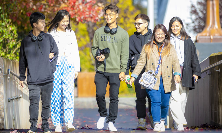 A group of international students walking through campus.