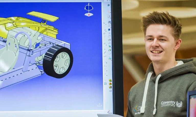 Male Aston Martin degree apprentice presenting on a large screen