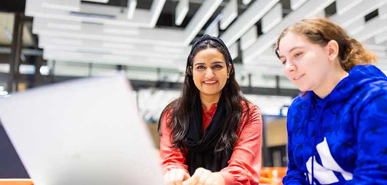 Two people working together with a laptop in front of them