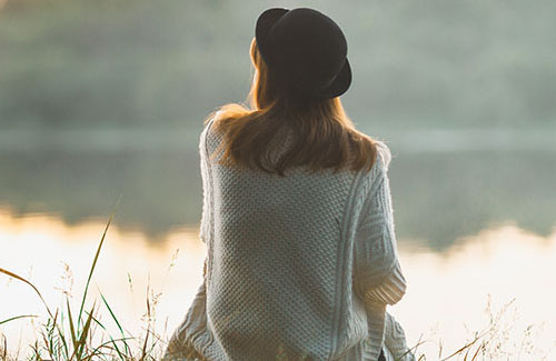 A female student sitting and thinking outside