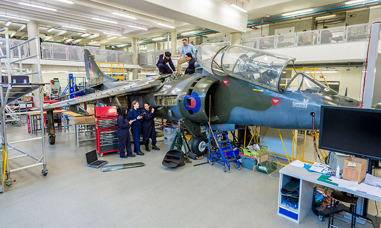 Students working on a Harrier T4 in an engineering suite