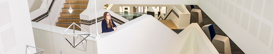Female student looking out from visually pleasing staircase