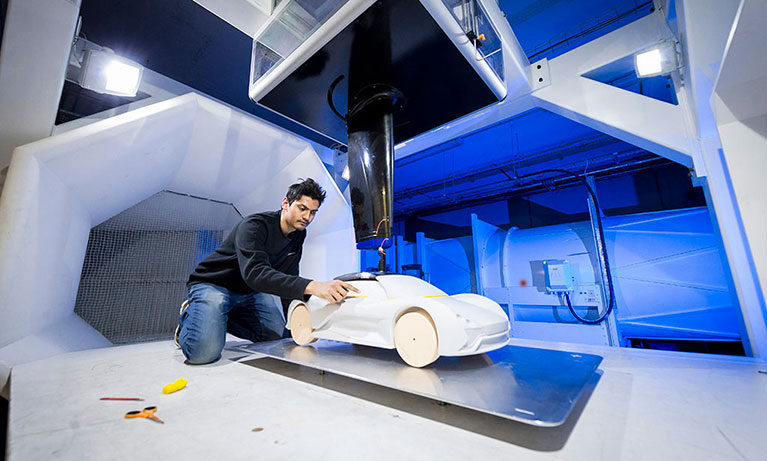 Stduent testing a model car in the wind tunnel
