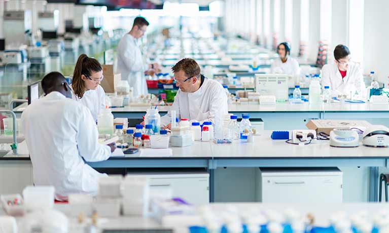 People working in the SuperLab with lots of bottles in front of them