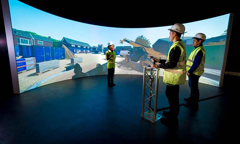 People dressed in construction gear looking at screen in the Simulation Centre