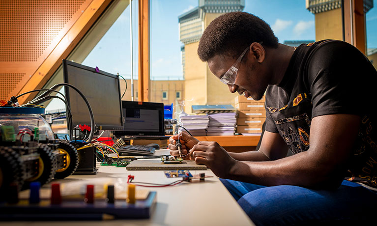 Student soldering on a development board 