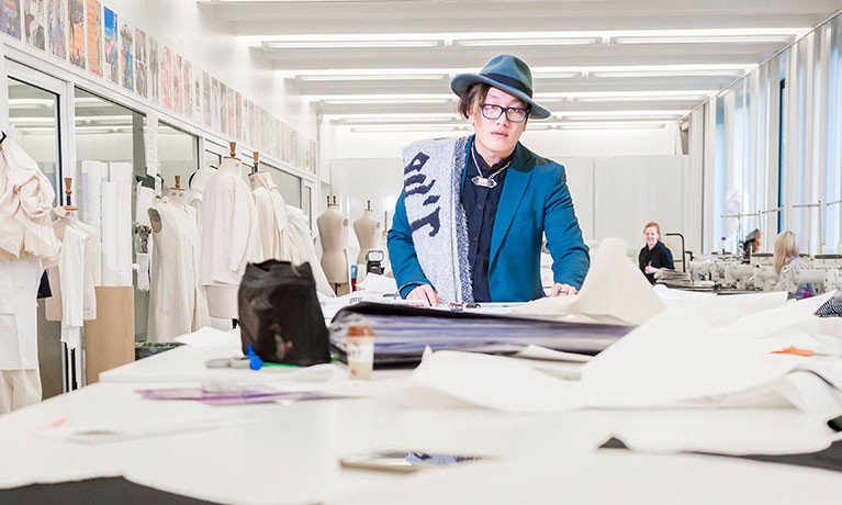 Student in fashion studio, working with fabric.