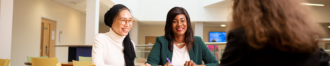 Two woman across a table smiling
