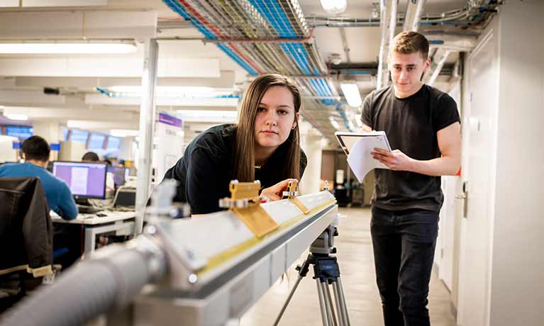 Two people with one making notes at what they've observed