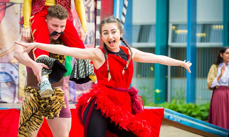 Women in a red costume performing and smiling