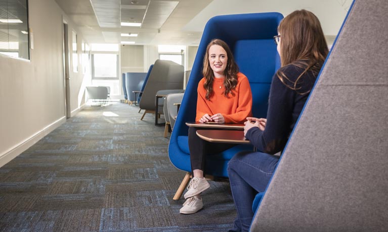 Two female students sat talking in a study area