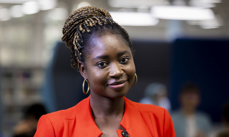 Students smiling at the camera in a university building