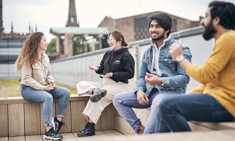 two ladies and one man talking on a couch